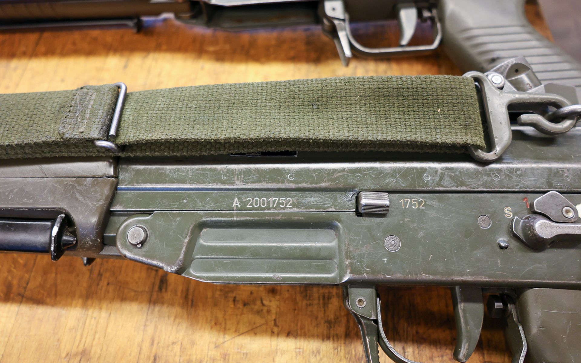 We can see the middle part of a rifle and the stamped weapon serial number.