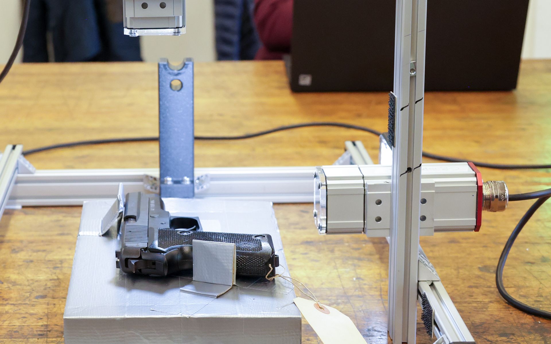In the centre, we see the system for automatic scanning of weapon serial numbers on a table.